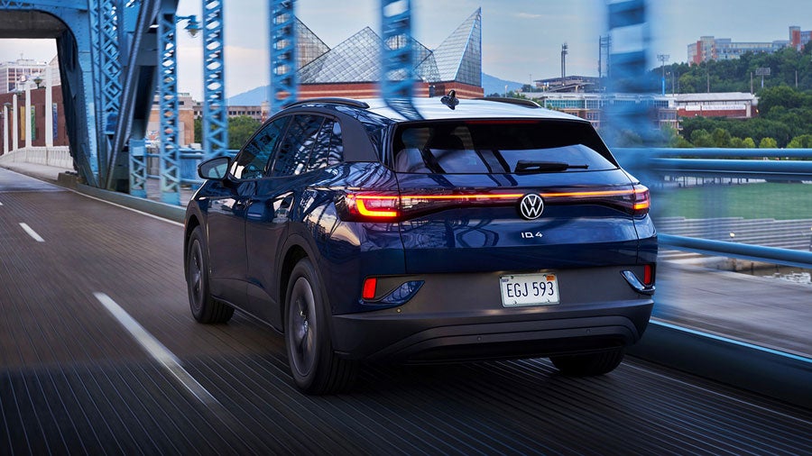 An ID.4 in Tourmaline Blue Metallic drives along a city street.